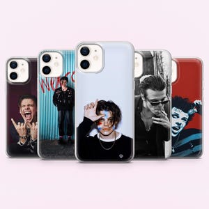 May include: A collection of five phone cases featuring images of a male musician. The cases display various portraits, including a black and white photo and images with colorful face paint. The cases are designed for an iPhone.