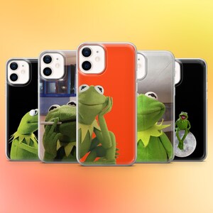 May include: A selection of phone cases showcasing Kermit the Frog in different poses. The cases feature Kermit against black, orange, and clear backgrounds. The frog is green with a yellow collar. The cases are for a smartphone.