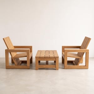 May include: A set of outdoor furniture consisting of two wooden armchairs and a matching rectangular coffee table. Each piece is constructed from light brown wood with a slatted design, featuring thick square frames and angled backrests.