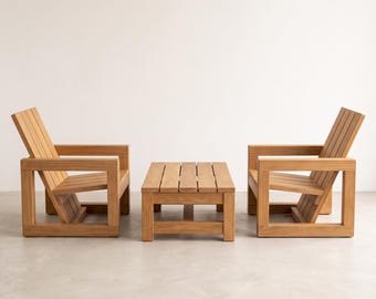May include: A set of outdoor furniture consisting of two wooden armchairs and a matching rectangular coffee table. Each piece is constructed from light brown wood with a slatted design, featuring thick square frames and angled backrests.