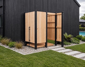 May include: An outdoor shower enclosure featuring vertical light-toned wooden slats, a matching wooden floor base, and a black metal frame. The structure is positioned against a black exterior wall, with a black pipe visible on the side panel.