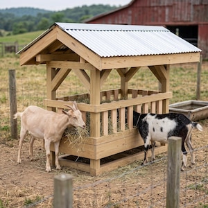 May include: A wooden hay feeder for livestock featuring a gabled roof with a silver corrugated metal covering. The structure has vertical wooden slats forming a feeding enclosure, with a light tan goat and a black and white goat eating hay.