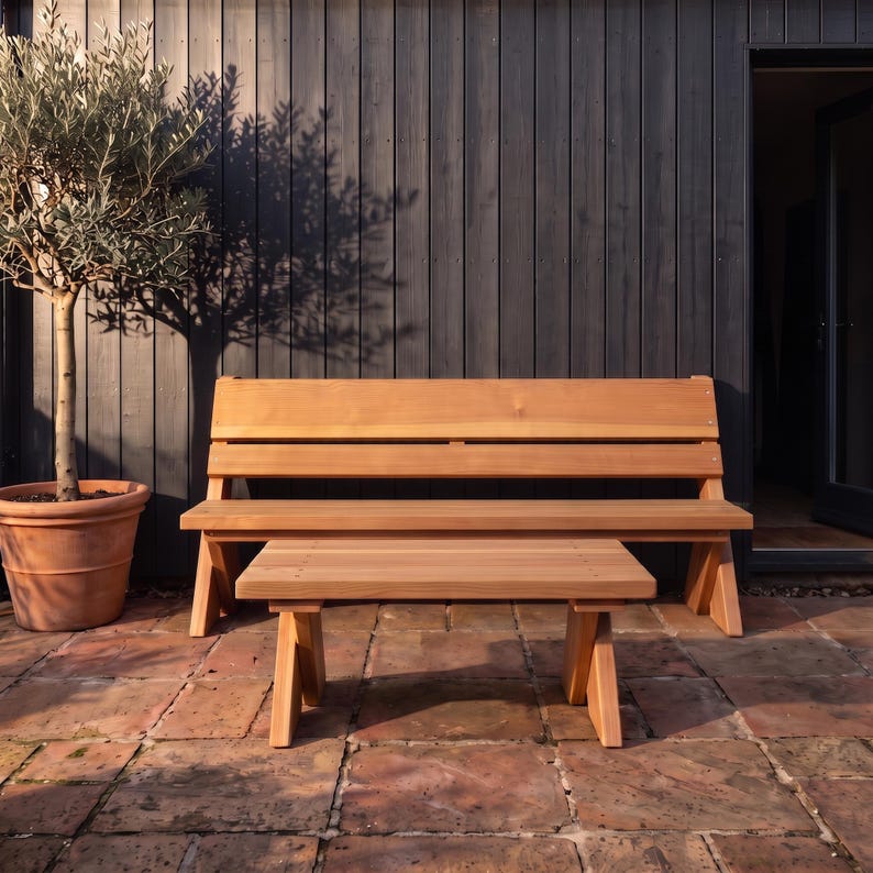 May include: A light brown wooden bench with a horizontal slat backrest and a matching low rectangular wooden coffee table positioned in front of it. Both pieces of furniture feature a smooth finish and sturdy angled legs for support.
