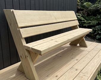 May include: A light-colored wooden bench featuring a backrest composed of two horizontal planks and a seat made of two horizontal planks. The bench has angled side supports that form a V-shape, constructed from natural wood with visible grain.