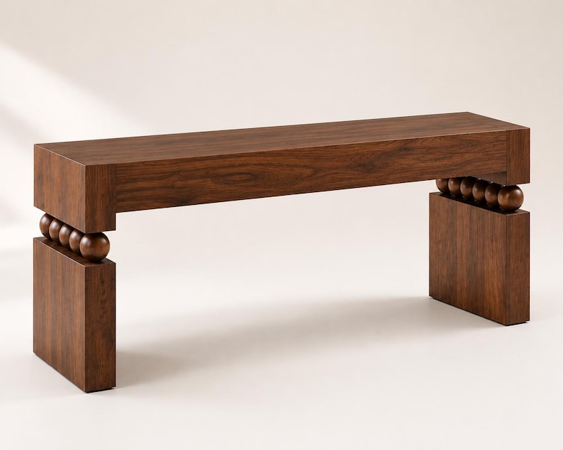 May include: A dark brown wooden bench featuring a rectangular seat and two solid rectangular legs. The seat is connected to each leg by a row of four spherical wooden beads, creating a distinct gap between the top and the base structure.