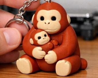 Llavero esculpido de una mamá orangután bebé, multicolor, impreso en 3D y pintado a mano.