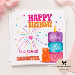 May include: A birthday card with the words "Happy Birthday" in pink and orange. The card features a stacked cake with the name "Isla" and the number "9". A gummy bear and the text "To a special Daughter" are also included.