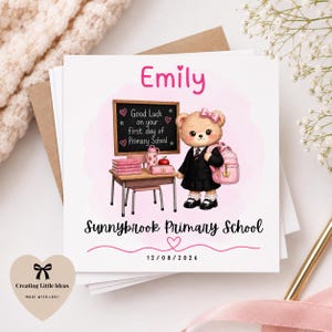 Może przedstawiać: Kartka z życzeniami z kreskówkowym misiem w mundurku szkolnym i różowym plecaku. Na górze kartki napisano "Emily", a na tablicy "Powodzenia w pierwszym dniu szkoły podstawowej". Szkoła nazywa się "Sunnybrook Primary School".