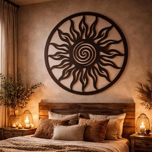 May include: A cozy bedroom with a wooden headboard and a large, circular sunburst wall art. The bed is covered with a brown blanket and pillows. Candles and lamps provide warm lighting, creating a relaxing atmosphere. The room has a bohemian theme.