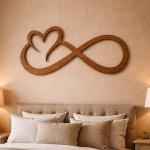 Puede incluir: Un símbolo de infinito de madera con forma de corazón, montado en una pared beige sobre una cama. El dormitorio presenta una paleta de colores neutros, con mesitas de noche y lámparas a juego.