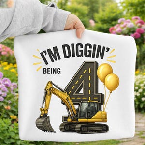 May include: White pillow with a yellow excavator graphic and the text "I'M DIGGIN' BEING 4". The number 4 is designed as a road, with two yellow balloons.
