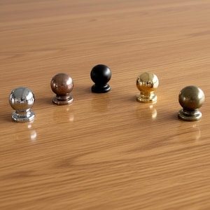 Può includere: Una tazza di ceramica bianca con manico nero e la scritta "But First, Coffee" in grassetto nero. La tazza è posta su uno sfondo sfocato. La tazza misura circa 10 cm di altezza.