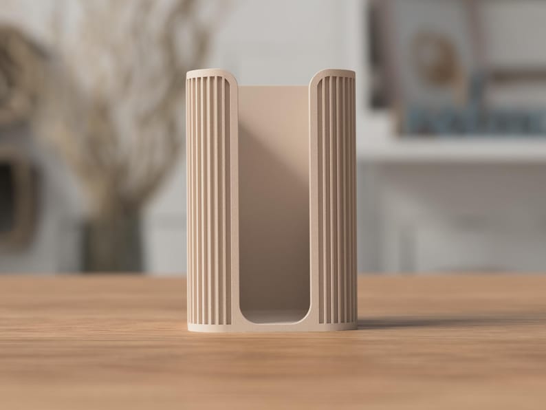 May include: A beige, rectangular holder with vertical ribbed detailing on the sides. The open-faced design allows for easy access to the contents. The holder is made of a solid material and sits on a wooden surface.