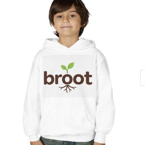Può includere: Felpa con cappuccio bianca con la scritta "broot" in marrone, un germoglio verde e una grafica di radici. La persona indossa jeans blu.