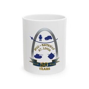 May include: White ceramic mug with a gold and blue design featuring the Gateway Arch, tanks, and the text "IPMS - Gateway St. Louis 1975 50 Years 2025".