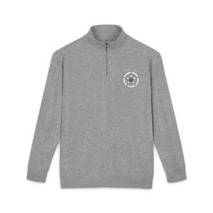 May include: A gray long-sleeve sweatshirt with a quarter-zip collar. The sweatshirt features a circular emblem with a star design on the left chest. The emblem has white, blue, and silver accents. The sweatshirt is made of a soft, comfortable material.