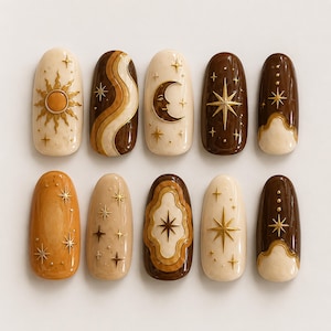 May include: A set of ten oval-shaped press-on nails featuring a celestial theme with gold-toned sun, moon, and star motifs. The colour palette includes shades of cream, tan, ochre, and dark brown, with glossy finishes and raised 3D embossed details.