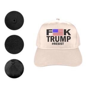 May include: A beige baseball cap with the text "F*K TRUMP" in black, with an American flag graphic and the word "#RESIST" below. The cap has a curved brim and a button on top.