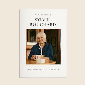 Peut inclure: Une carte commémorative avec le texte À LA MEMOIRE DE SYLVIE BOUCHARD et les dates 30 JANVIER 1958 - 10 JUIN 2026. Au centre, une photographie d'une personne souriante aux cheveux blancs courts portant une chemise bleue à une table.