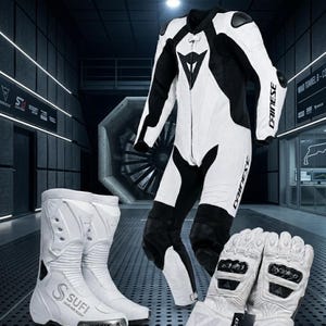 K&ouml;nnte beinhalten: Ein wei&szlig;-schwarzes Motorrad-Rennanzug-Set mit Stiefeln und Handschuhen. Der Anzug hat ein Dainese-Logo und ein stromlinienf&ouml;rmiges Design. Die wei&szlig;en Stiefel tragen das Logo "SUFI LEATHER POINT". Die Handschuhe sind wei&szlig; mit schwarzen Akzenten.