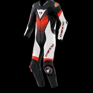 May include: A black, white, and red motorcycle racing suit. The suit features white panels on the arms and legs, with red accents and the brand name "DAINESE" printed on the arms and legs. The suit has a front zipper and protective padding.