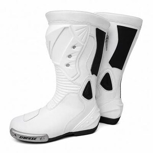 K&ouml;nnte beinhalten: Wei&szlig;e Motorradstiefel mit schwarzen Akzenten. Die Stiefel haben ein stromlinienf&ouml;rmiges Design mit Schutzfunktionen, einschlie&szlig;lich verst&auml;rkter Paneele und einem Rei&szlig;verschluss. Der Markenname "Dainese" ist sichtbar.