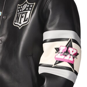 Peut inclure: Veste en cuir noire avec &eacute;cusson du logo NFL sur la poitrine. La manche pr&eacute;sente un motif blanc, gris et noir avec une &eacute;toile et le texte "SUPER BOWL LX" en rose.