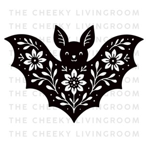 May include: A black bat silhouette featuring white floral and leaf patterns on its wings and body. The design includes a central flower and symmetrical foliage. The text THE CHEEKY LIVINGROOM is repeated in the background in a light gray font.