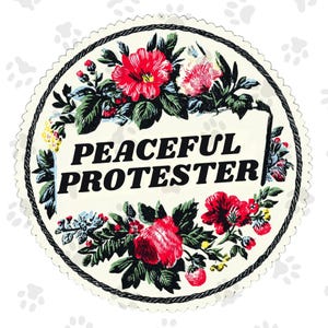 May include: A circular patch with a floral design and the words "PEACEFUL PROTESTER" in bold black letters. The flowers are red, pink, and white, with green leaves, set against a cream background. The patch has a scalloped edge and a black rope border.