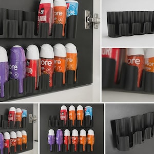 Könnte beinhalten: Ein schwarzes Wandregal aus Kunststoff mit mehreren vertikalen Schlitzen zur Aufbewahrung kleiner Flaschen. Das Regal hat ein wellenförmiges, modulares Design und ist mit verschiedenen bunten Sirupflaschen mit weißen Verschlüssen bestückt.