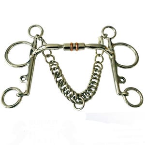 May include: A stainless steel horse bit featuring a curb chain and two copper rings at the center of the mouthpiece. The bit includes side shanks with multiple rings for attachment, showcasing a polished metallic finish and a complex mechanical design.