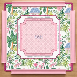 Könnte beinhalten: Ein rosa-weißes Spielbrett mit floralem und architektonischem Design. In der Mitte befinden sich die Initialen "RWH" in einem rosa gemusterten Rahmen. Das Brett enthält rosa Schienen und Text, der Spielanweisungen angibt.