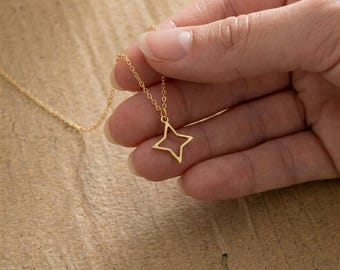 Colar delicado com pingente de estrela dourada, joia minimalista celestial para sobreposição de peças.