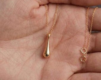 Colar com pingente em forma de lágrima em ouro amarelo 18K, joia minimalista para o dia a dia com efeito de gota líquida.