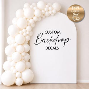 Op de afbeelding: Een witte boogvormige achtergrond met de tekst "CUSTOM Backdrop DECALS" in zwart script. Een slinger van witte ballonnen loopt in een boog langs de linkerkant. Een gouden cirkel met tekst en een vrachtwagenpictogram staat rechtsboven.