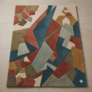 May include: A rectangular area rug featuring a geometric pattern of interlocking shapes in shades of terracotta, teal, olive green, mustard yellow, and cream. The design consists of angular, multi-sized polygons with a textured, tufted surface.
