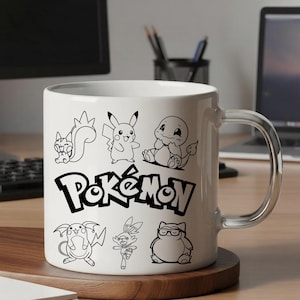 May include: White ceramic mug featuring black line drawings of various Pok&eacute;mon characters and the word "Pok&eacute;mon" in a bold font. The mug has a clear handle and is set on a wooden coaster.