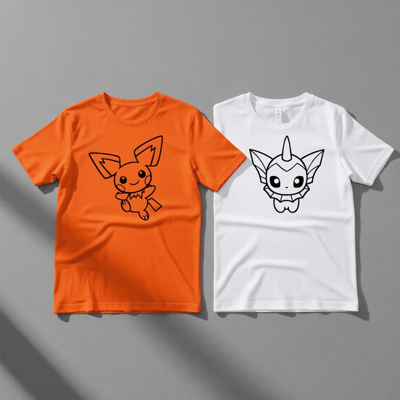 May include: Two short-sleeved t-shirts. One is orange with a black cartoon character design. The other is white with a different black cartoon character design. Both shirts are on a gray background.