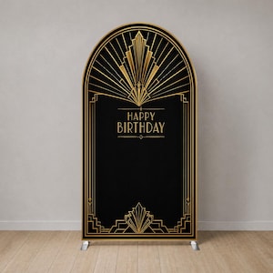 Puede incluir: Un soporte de fondo arqueado con una cubierta de tela negra que presenta líneas geométricas doradas y el texto HAPPY BIRTHDAY centrado. El diseño incluye patrones de rayos de sol en la parte superior e inferior con líneas simétricas.