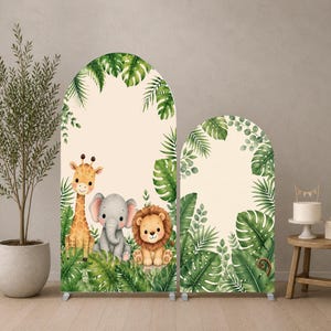 Può includere: Due coperture per fondali ad arco con un tema giungla ad acquerello. La copertura più alta mostra una giraffa, un elefante e un leone circondati da foglie tropicali verdi su sfondo crema. La copertura più corta presenta un fogliame verde abbinato.