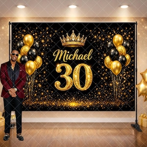 May include: A black and gold birthday backdrop with the name "Michael" and the number "30" in gold glitter. The backdrop is decorated with gold and black balloons, a gold crown, and gold star-shaped balloons. A person in a burgundy suit stands in front of the backdrop.