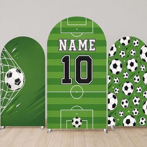 Può includere: Tre coperture per fondali ad arco a tema calcistico. Il pannello sinistro mostra un pallone da calcio in una rete. Il pannello centrale mostra un campo verde con il testo NAME e il numero 10. Il pannello destro presenta un motivo di palloni da calcio.