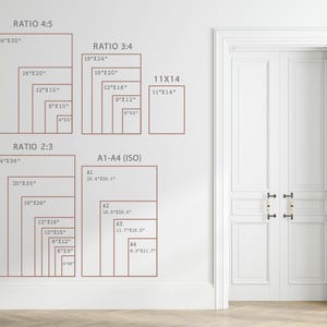May include: A white wall displays a size guide chart with text labels for Ratio 4:5, Ratio 3:4, 11x14, Ratio 2:3, and A1-A4 ISO, listing various dimensions in inches and centimeters for print sizes next to a white double door with gold handles.