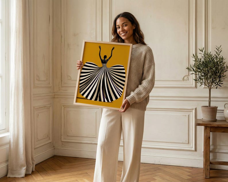 May include: A rectangular framed art print featuring a stylized illustration of a figure with arms raised, wearing a voluminous dress with bold black and white vertical stripes against a solid mustard yellow background.