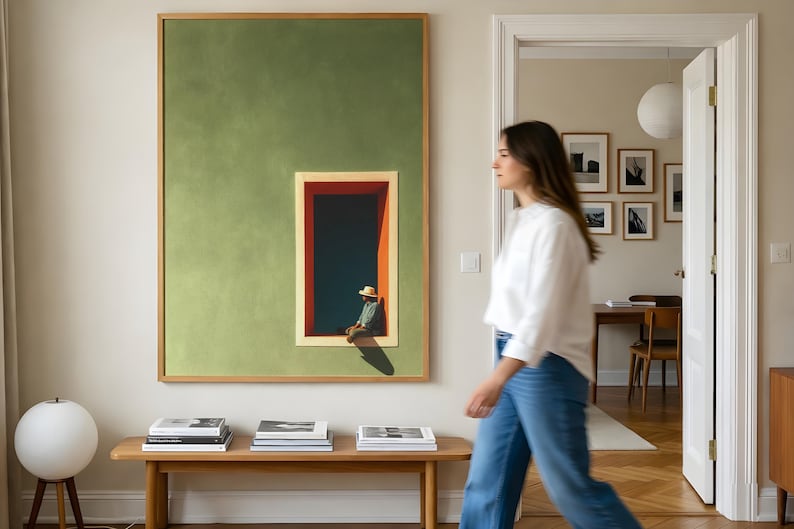 May include: A large rectangular wall art piece featuring a solid sage green background with a centered vertical window frame in red and orange. Inside the frame, a figure wearing a straw hat sits in a dark blue space with a sharp shadow cast below.