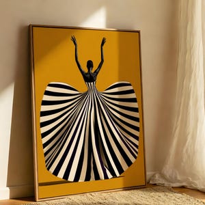 May include: A framed rectangular wall art print featuring a figure with dark skin and raised arms, wearing a voluminous gown with bold black and white vertical stripes against a solid mustard yellow background, set in a light wood frame.