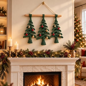 May include: A wall hanging featuring three macrame Christmas trees in dark green cord, suspended from a light wooden dowel with a rope hanger. Each tree is decorated with small, round, shiny red and gold ornaments and finished with a tassel.