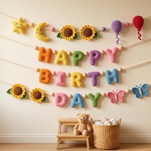 May include: A multi-colored crochet banner spelling out HAPPY BIRTH DAY, featuring stuffed shapes including a yellow star, crescent moon, sunflowers, purple and red balloons, and pink and blue butterflies, suspended on four white ropes.