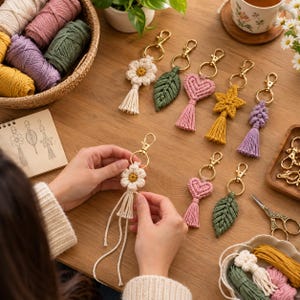 May include: A collection of handmade macrame keychains featuring various shapes including flowers, leaves, hearts, and stars in colors like cream, green, pink, yellow, and purple, each attached to a gold-toned metal lobster clasp and keyring.
