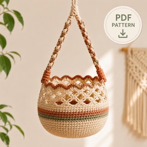 May include: A hanging crochet basket featuring a cream-colored base with horizontal stripes in terracotta and sage green. The upper section has an openwork floral pattern and a scalloped rim in terracotta. It includes a braided hanging strap. PDF PATTERN.